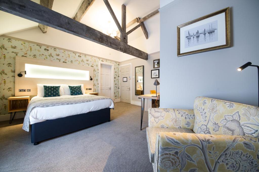 a bedroom with a bed and a couch at The Fox House by Innkeeper's Collection in Hathersage