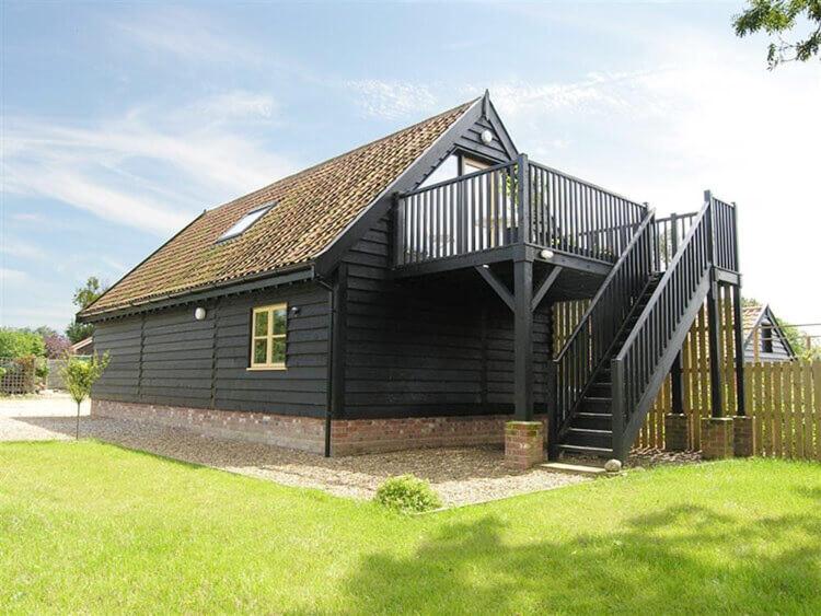 a black house with a staircase on top of it at Weavers Loft in Erpingham