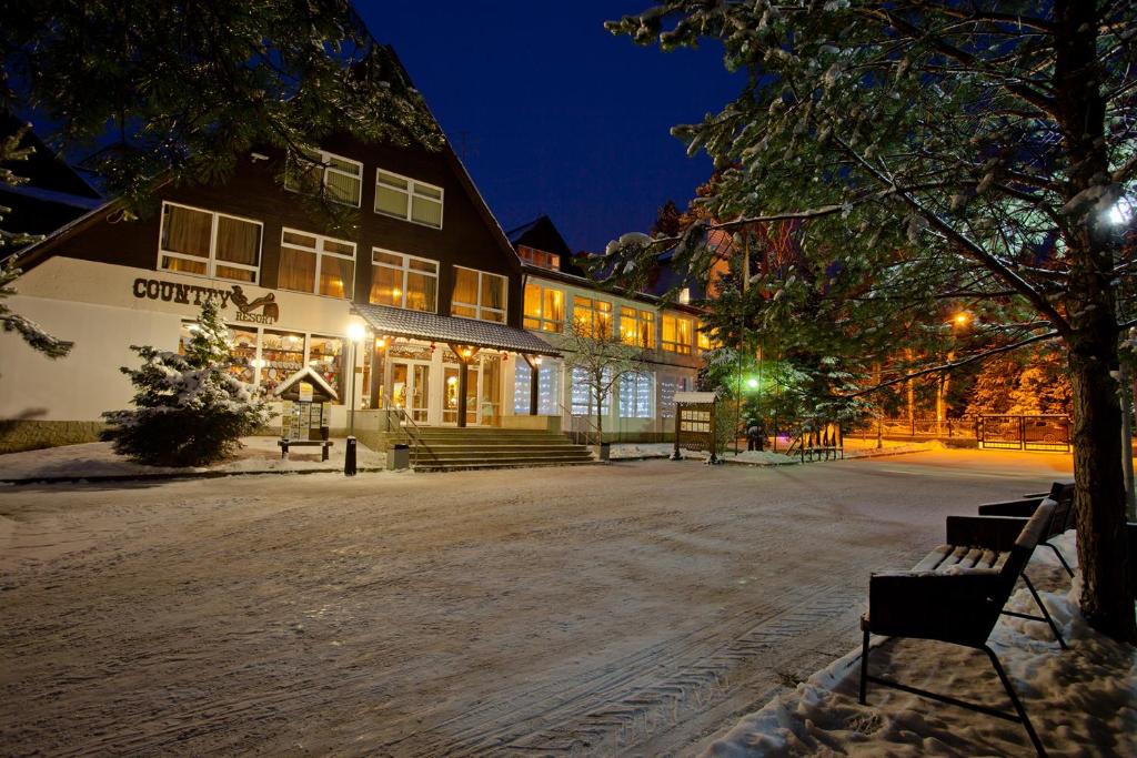 a bench in front of a building at night at Country Resort Hotel in Verbilki