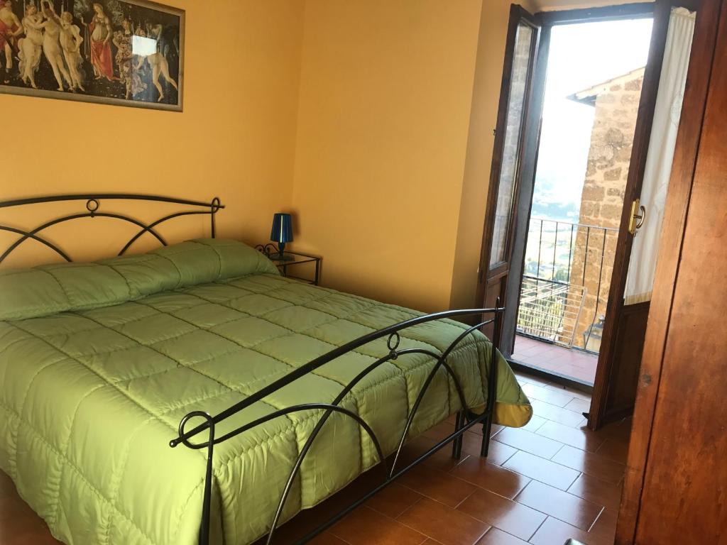 Schlafzimmer mit einem Bett mit grüner Tagesdecke in der Unterkunft Casa Iolanda in Orvieto