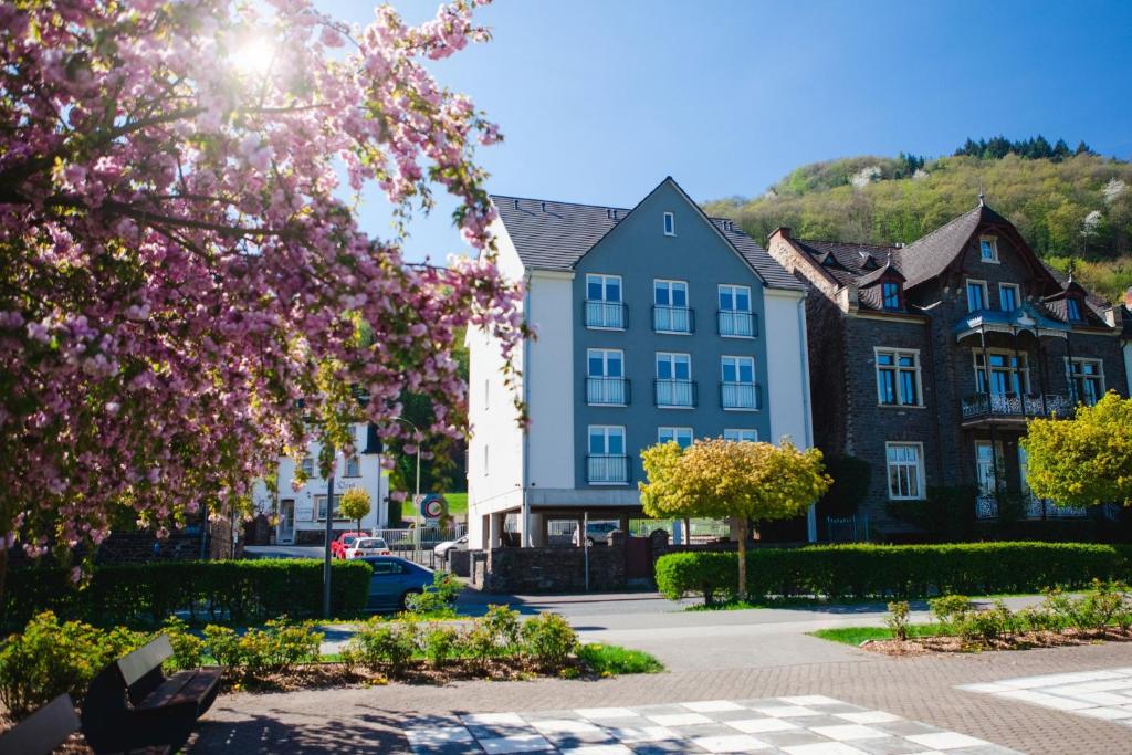 una fila de casas en un pueblo con flores rosas en aparthotel Cochem en Cochem