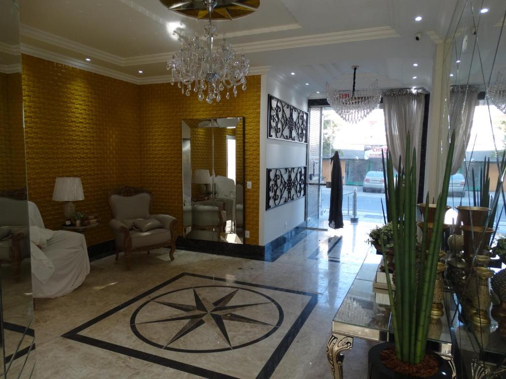 a lobby with a chandelier and a living room at Apartamento Avenida F in Bombinhas