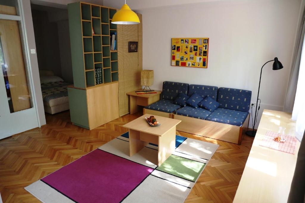 un soggiorno con un divano blu e un tavolo di Supercozy Studio a Skopje