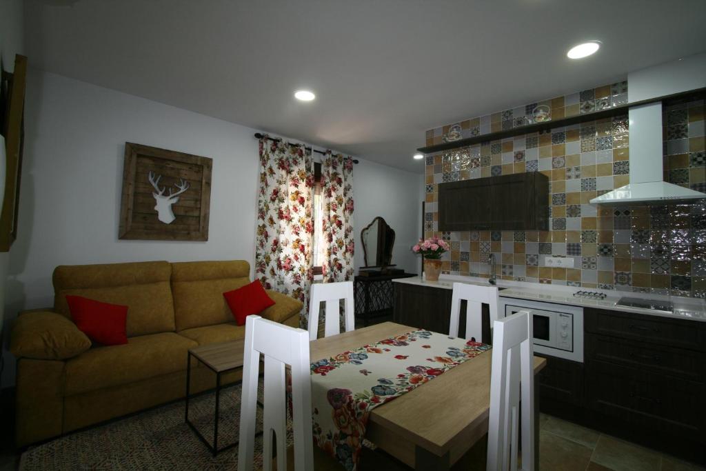 a kitchen and living room with a table and a couch at Apartamentos mirasierra plaza in Coto Rios
