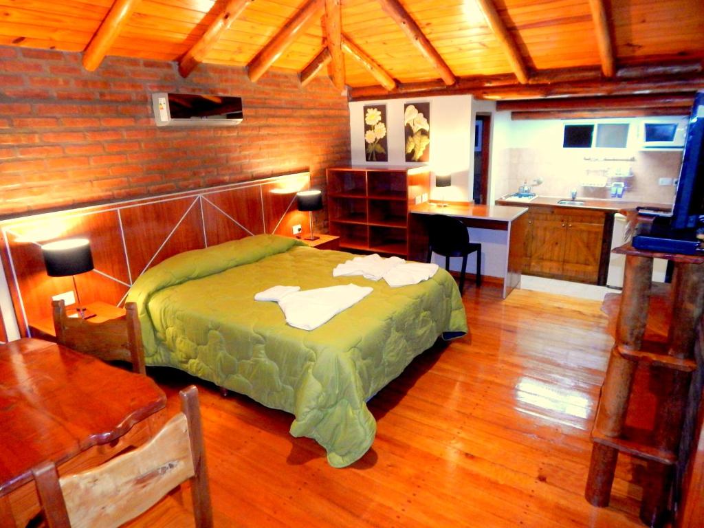 a bedroom with a bed and a kitchen in a room at Pachanavira Cabañas & Suites in Nono