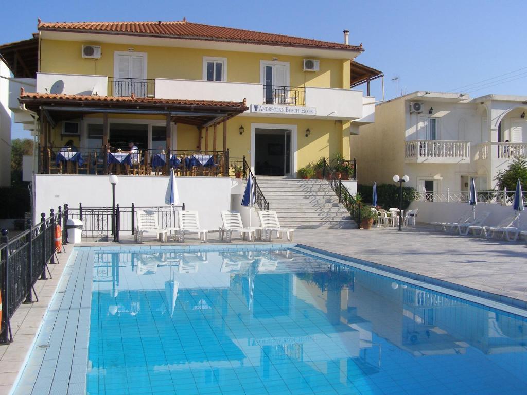 a villa with a swimming pool in front of a house at Andreolas Beach Hotel in Laganas