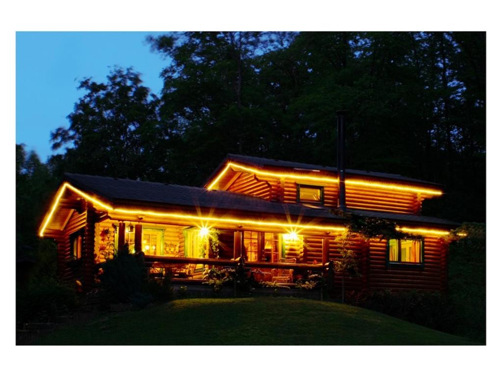 a log cabin lit up at night with lights at Tumbleweed House in Aigrefeuille