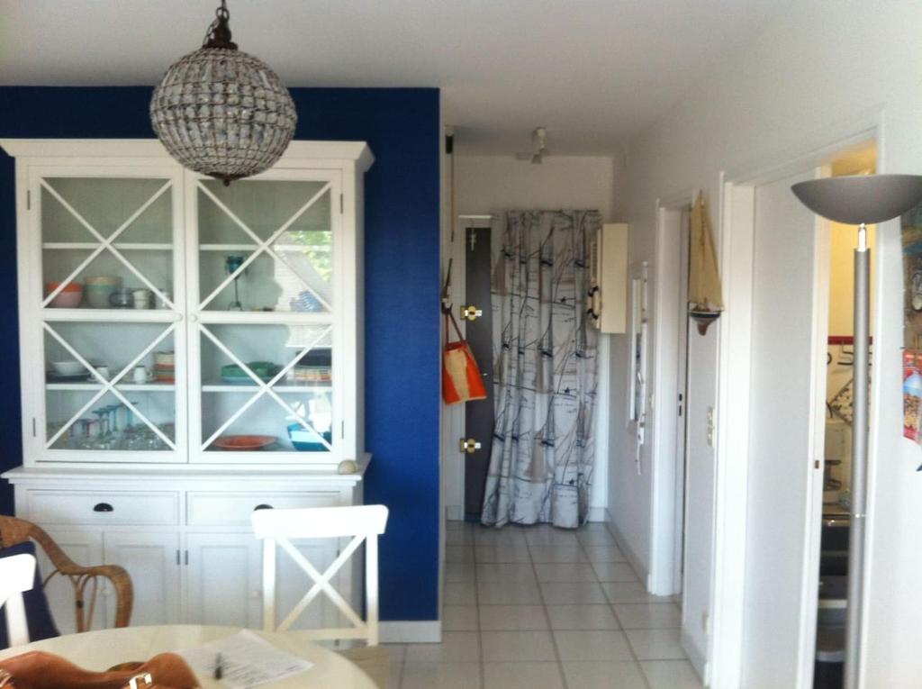 une chambre avec un mur bleu et une salle à manger dans l'établissement NICE FLAT 50M BEACH & CENTER, à Cabourg