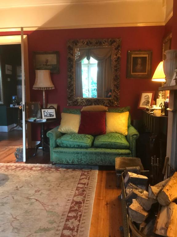 a living room with a green couch and a window at 10 st james villas in Winchester