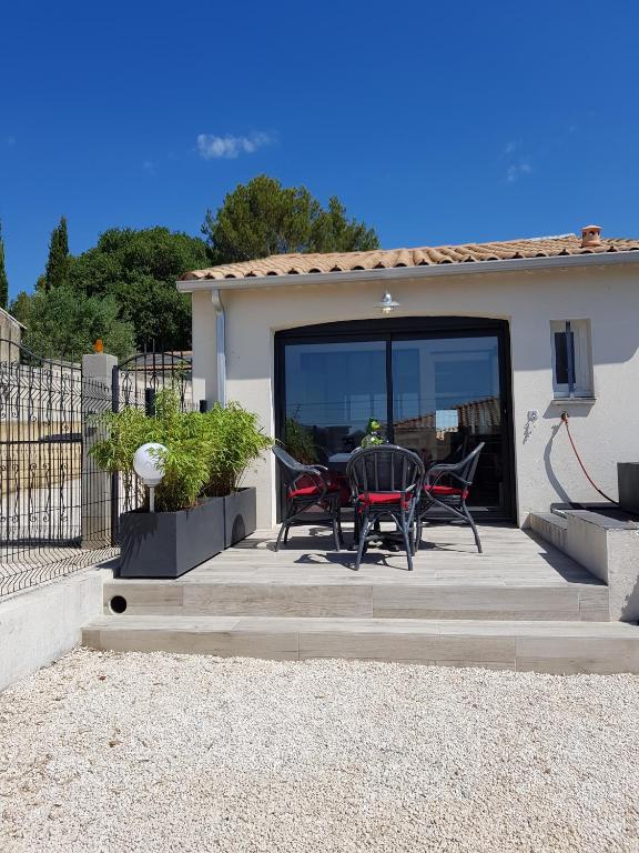 un patio avec une table et des chaises dessus dans l'établissement Gite les Coquelicots, à Lédenon
