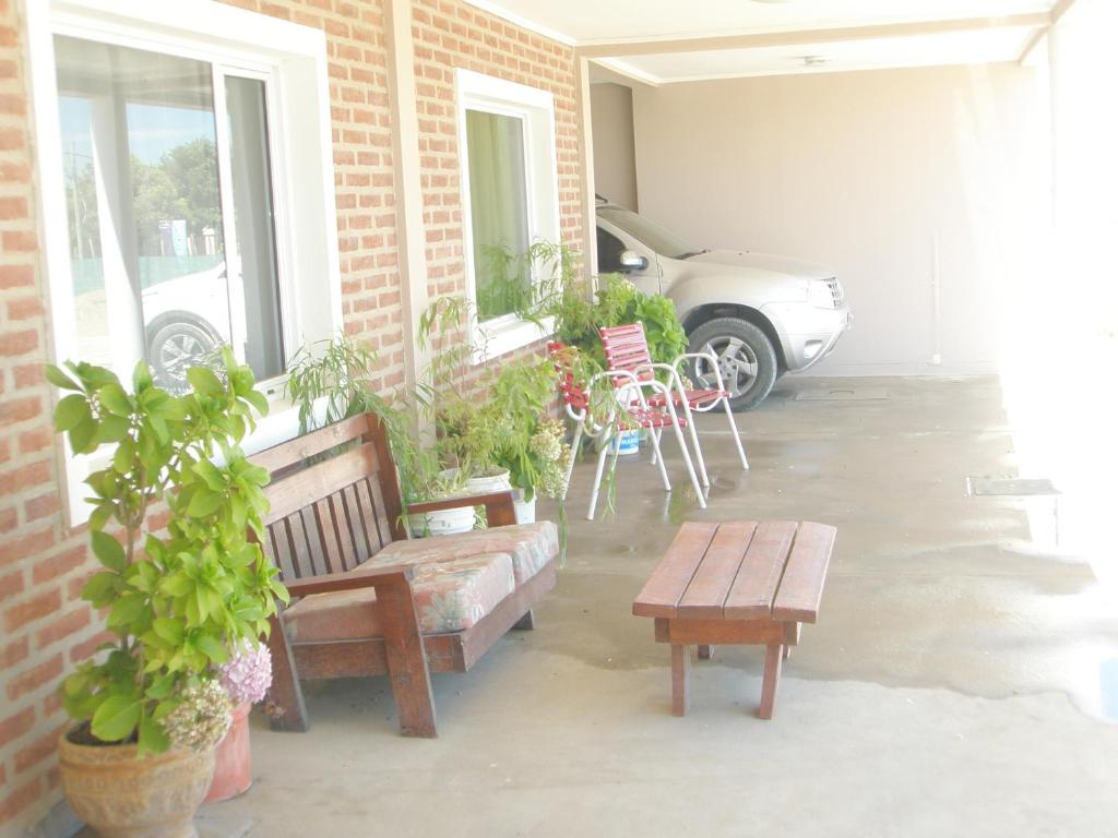 a patio with two benches and a table and a car at Sendero Patagonico in Las Grutas