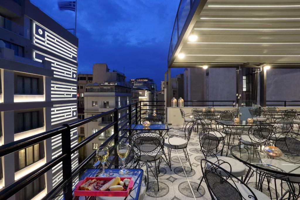 a balcony with tables and chairs on a building at V1935 Luxurious Apartments in Athens