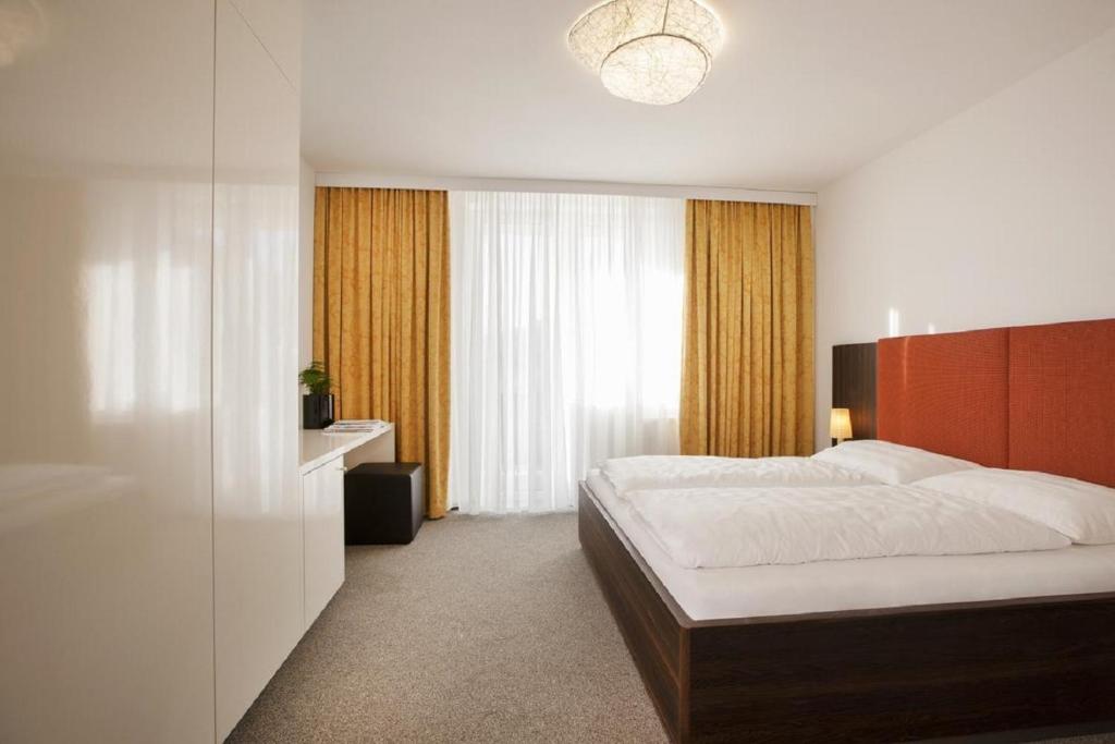 una camera da letto con un letto e una grande finestra di WIEDERERÖFFNUNG - TAUROA Schönberghof Spielberg a Spielberg