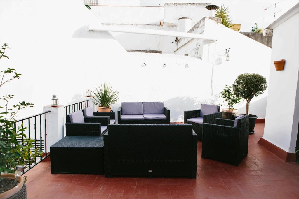 einen Balkon mit schwarzen Möbeln und Pflanzen in der Unterkunft Mateo Alemán 22 in Sevilla