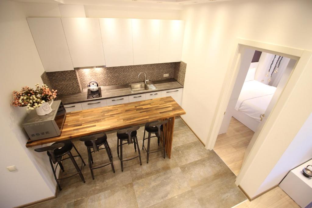 una pequeña cocina con mesa de madera y sillas en Super Luxury Apartments, en Tiflis