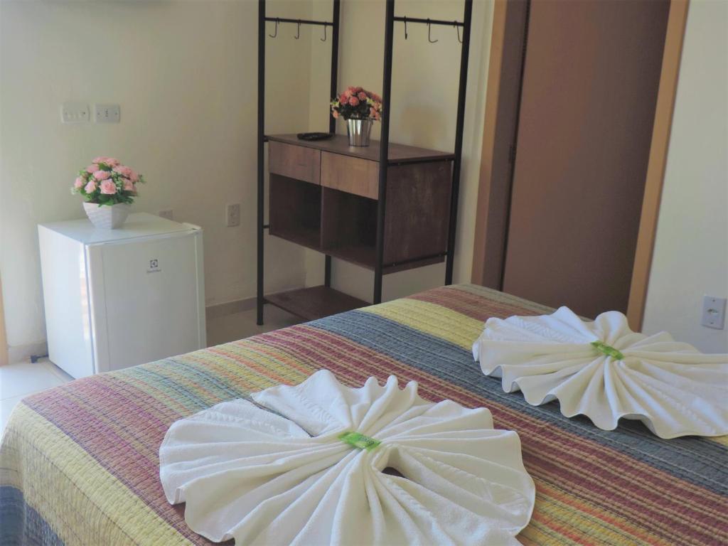 Un dormitorio con dos almohadas blancas sobre una cama. en Pousada Solar do Jabaquara, en Paraty