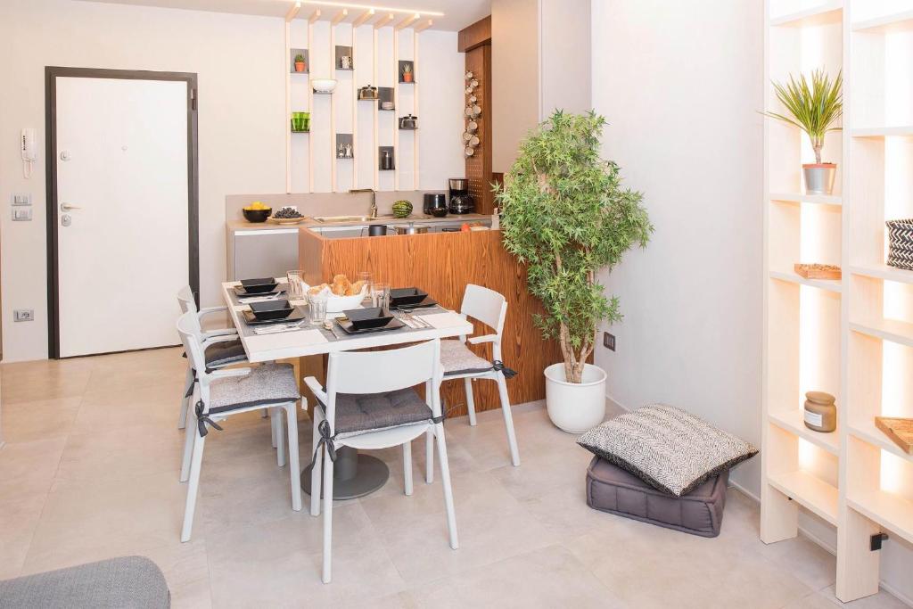a dining room with a white table and chairs at Green Flat in Bardolino
