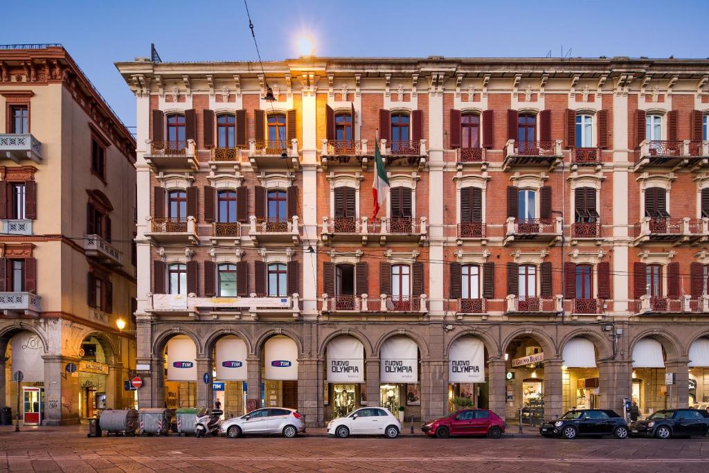 a large building with cars parked in front of it at Vela Rooms in Cagliari