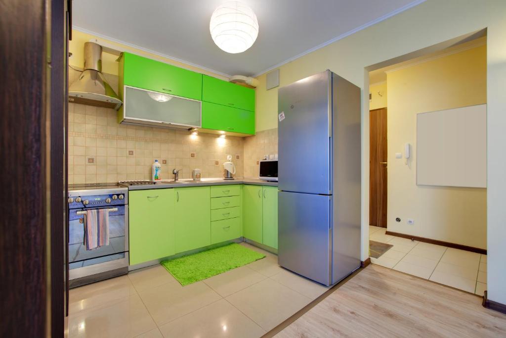 a kitchen with green cabinets and a blue refrigerator at Apartament 5 in Krakow