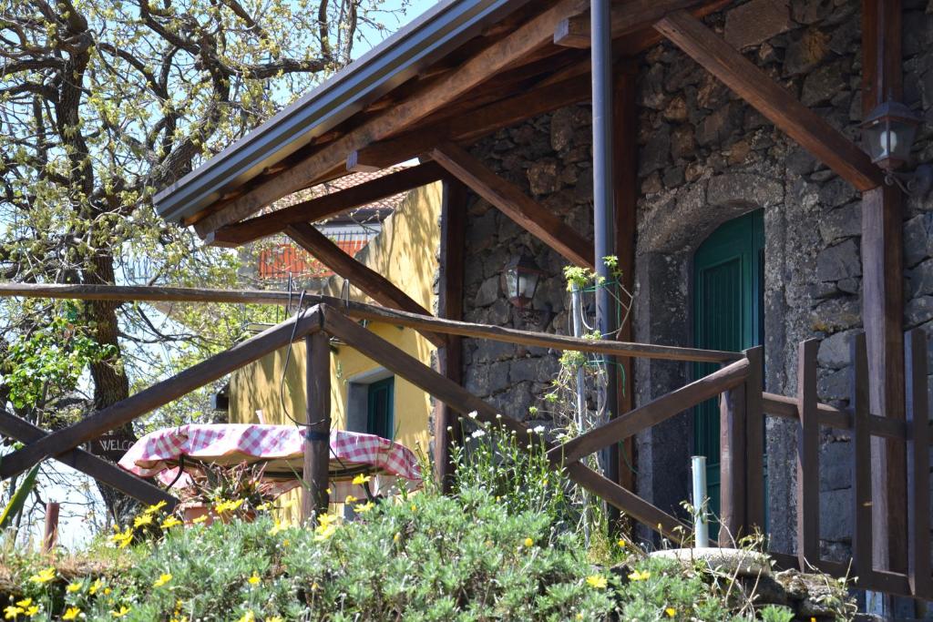 a stone house with a wooden fence in front of it at Casa Vacanza La Papuzza Mare e Etna in Mascali
