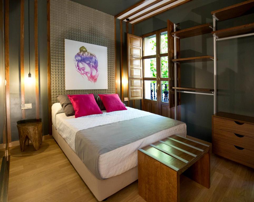 a bedroom with a large bed with pink pillows at San Justo Plaza in Salamanca