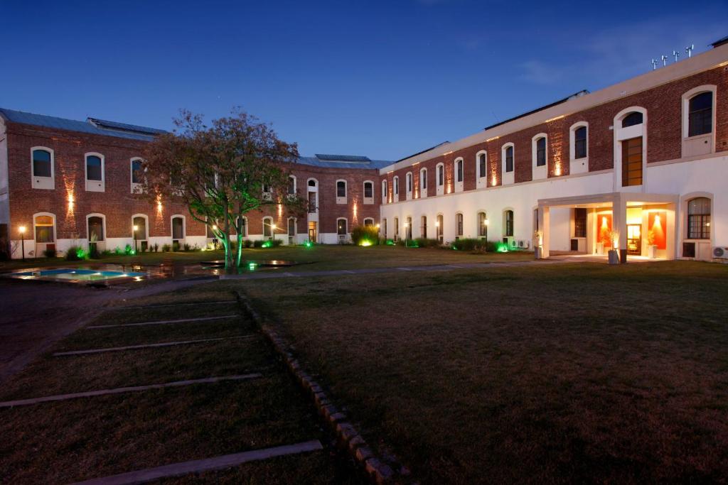 an empty parking lot in front of a large brick building at Complejo Los Merinos in Bahía Blanca