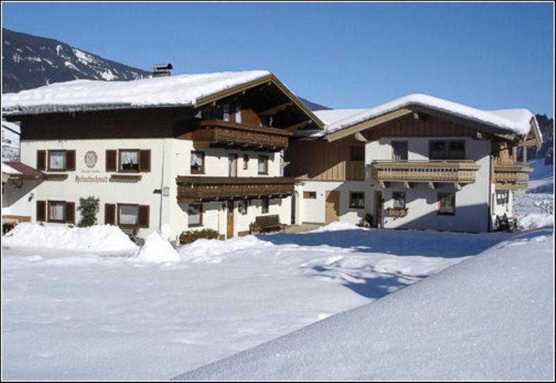 a large building with snow on top of it at Habachschmied Familie Gruber in Bramberg am Wildkogel