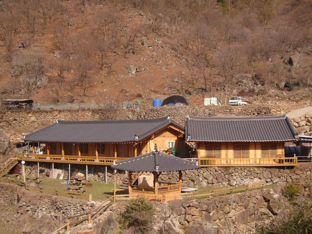 una gran casa de madera con techo negro en Buchungol Pension en Hadong