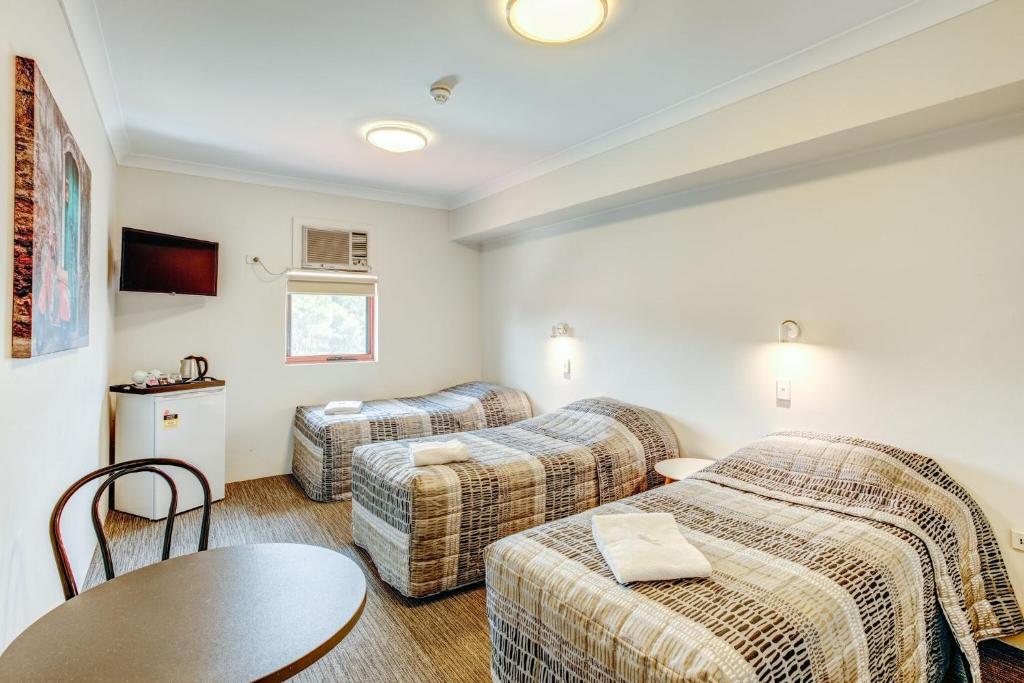 Postel nebo postele na pokoji v ubytování Arena Hotel (formerly Sleep Express Motel)