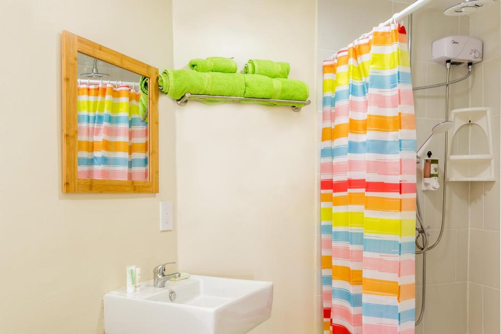 a bathroom with a sink and a colorful shower curtain at Serene by the Sea in Savaneta