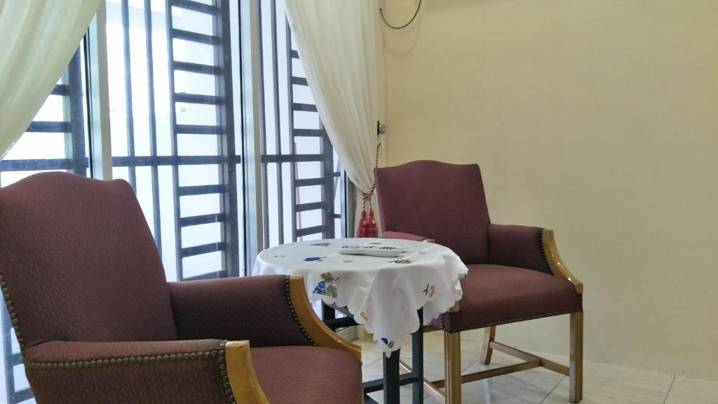 two chairs and a table in a room at Airis Homestay Changlun in Changlun