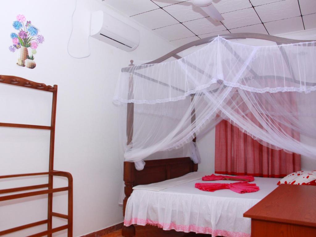 Schlafzimmer mit einem Bett mit Moskitonetz in der Unterkunft Moon Glow Guest in Mirissa