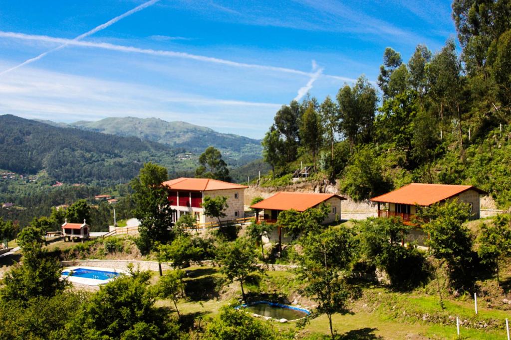 een huis op een heuvel met een zwembad bij Encostas da Torre in Terras de Bouro