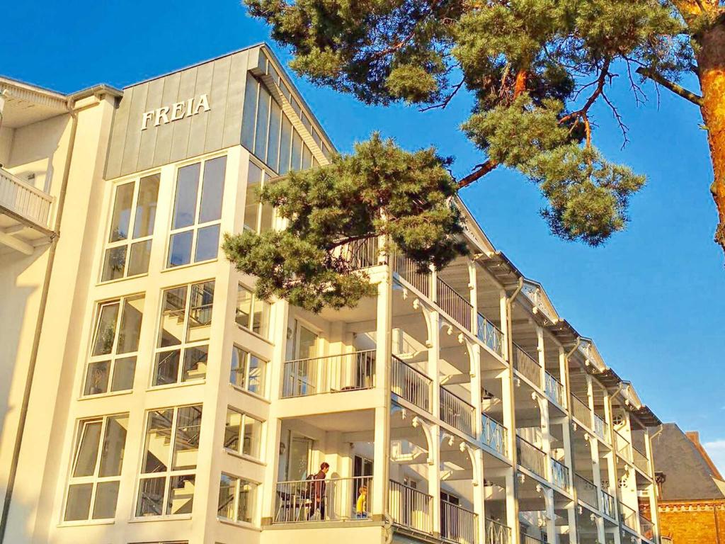 ビンツにあるVilla "Freia" in Binz - WG11 mit Meerblick und Balkonの白い大きな建物で、バルコニーに人がいます。
