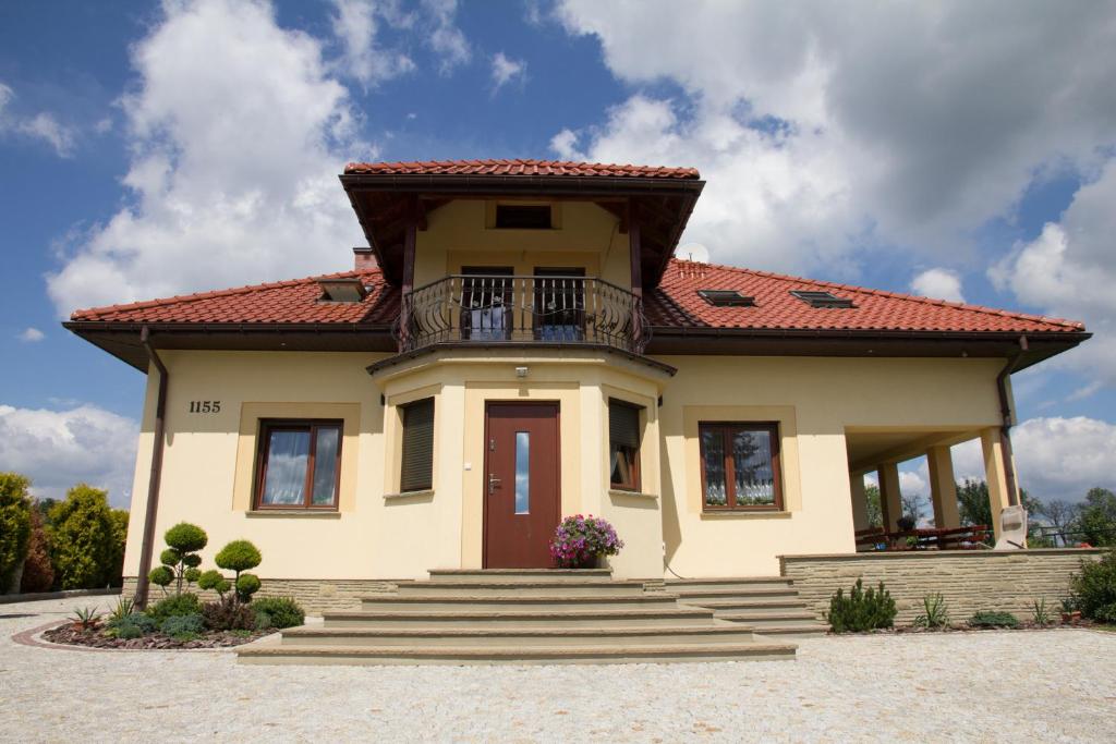 una pequeña casa amarilla con techo rojo en Pokoje Goscinne u Florka, en Słopnice