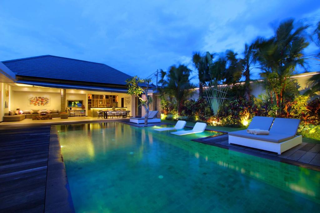 uma villa com piscina à noite em Villa Amba Laba by Optimum Bali Villas em Seminyak