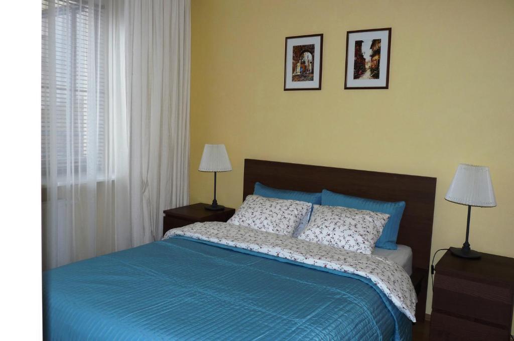 ワルシャワにあるWarszawa Zaciszeのベッドルーム1室(青いシーツとランプ2つ付)