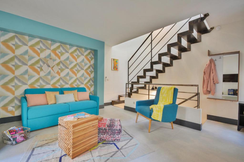 a living room with a blue couch and two chairs at Sweet Inn - Tardieu in Paris