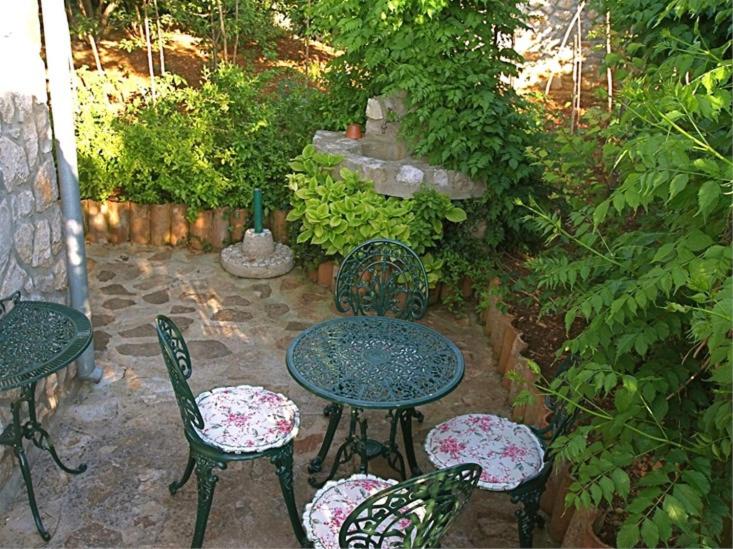 a patio with tables and chairs and a fountain at Apartments Cvita in Veli Lošinj