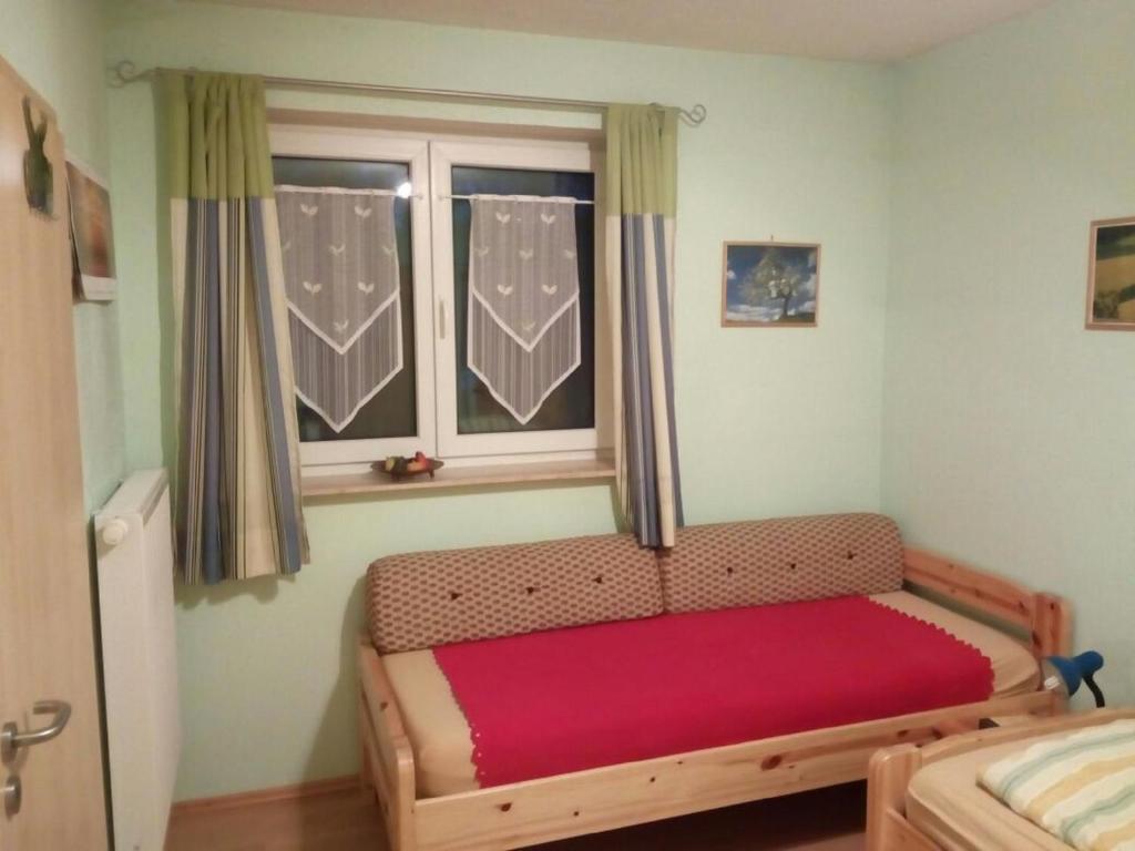 a small bedroom with a bed and a window at Pension "Am Tor zum Mainbogen" in Grettstadt