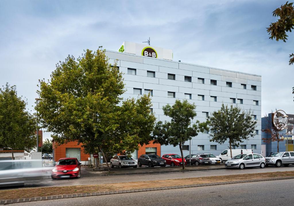 ein weißes Gebäude mit einer Uhr oben drauf in der Unterkunft B&B HOTEL Figueres in Figueres