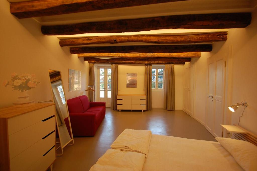 ein Wohnzimmer mit einem Bett und einem roten Sofa in der Unterkunft Rustico Moderno in Ghiffa
