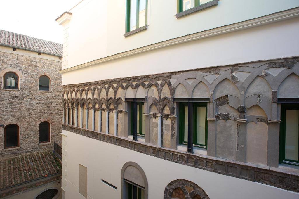 ein weißes Gebäude mit grünen Fenstern darauf in der Unterkunft Haripergo Apartments in Salerno