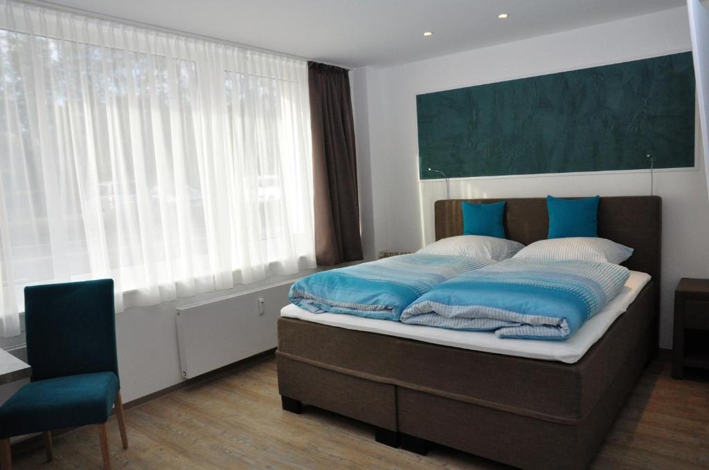 a bedroom with a large bed with blue pillows at Apartments am Freizeitpark in Kriftel