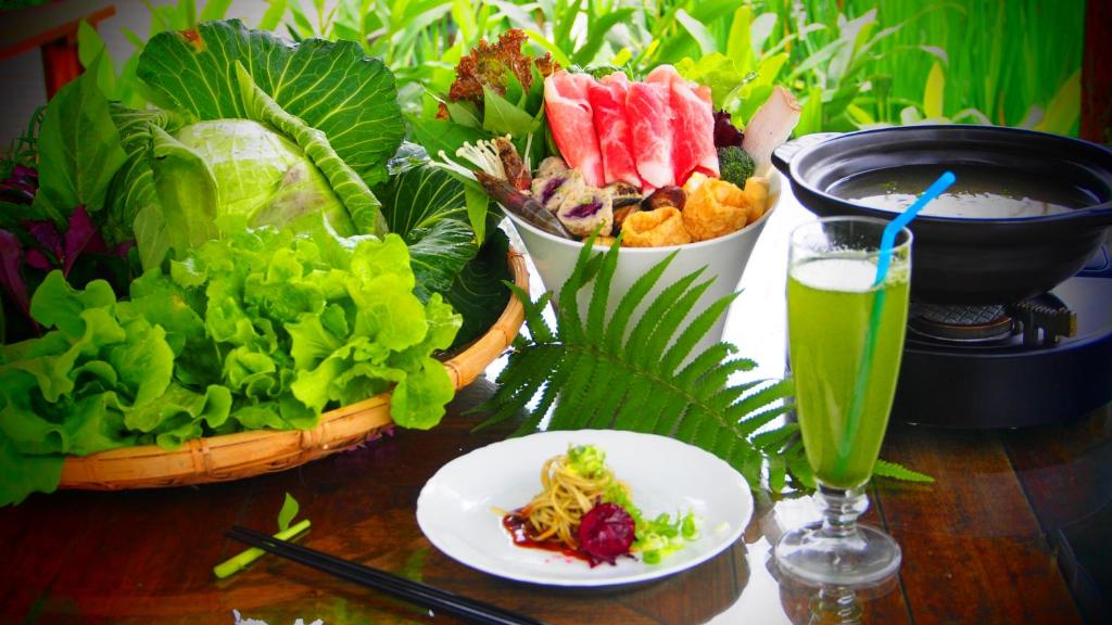 a table topped with plates of food and a drink at Fairy Story Village Farm B&amp;B in Dongshan