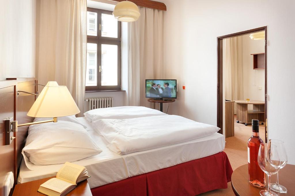 sypialnia z dużym białym łóżkiem i stołem w obiekcie B&B Hotel Praha w Nowym Jiczynie