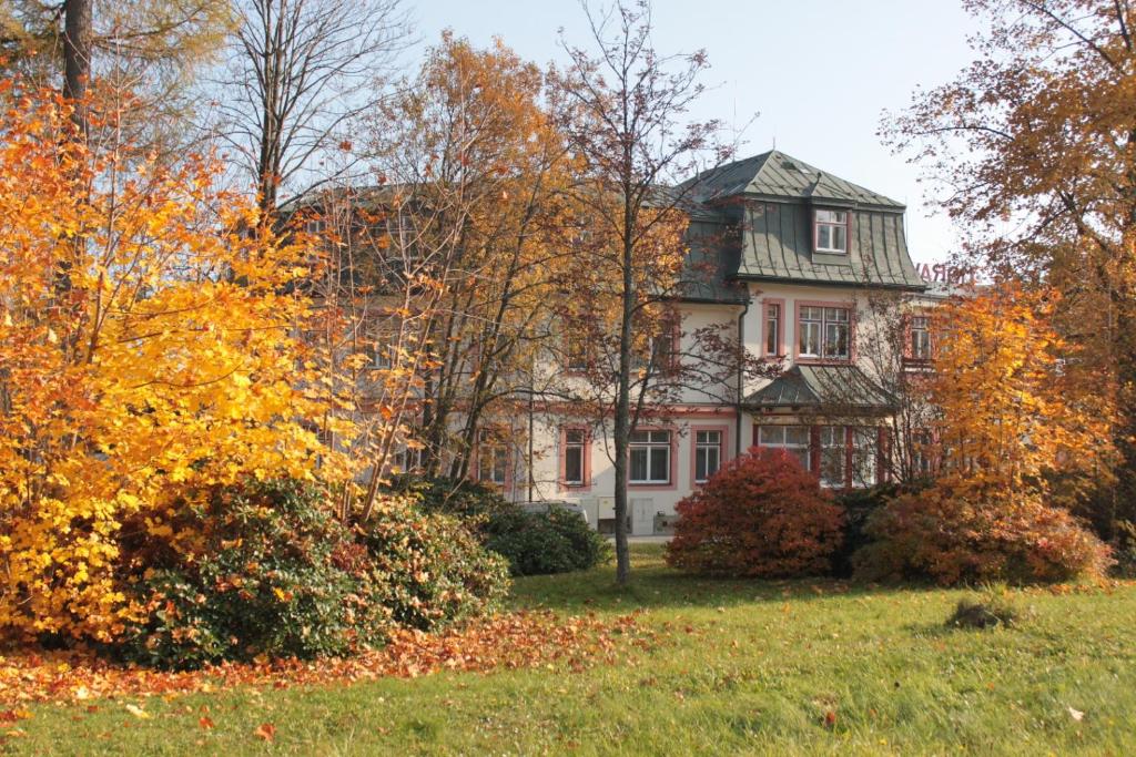 een oud huis in de herfst met bomen bij Tatranka a Horalka in Tatranská Lomnica