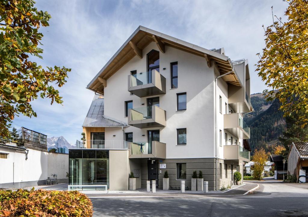 a white building with a gambrel roof at Appartements Marlene in Maishofen