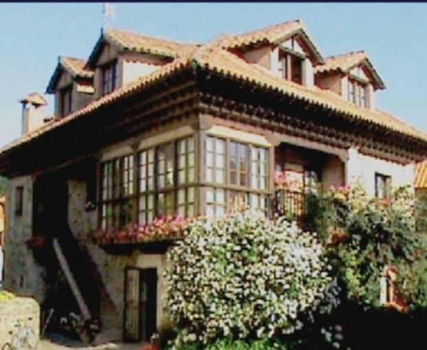 a large house with flowers in front of it at Posada La Casona De Ucieda in Ucieda de Arriba