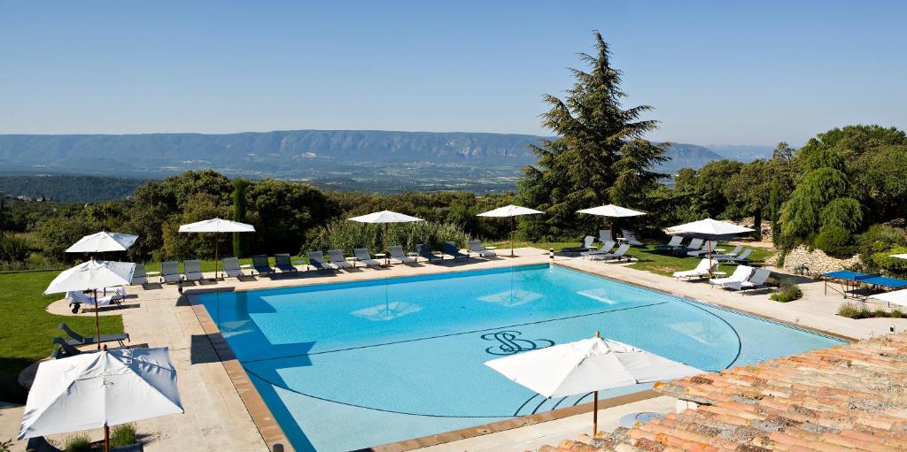 - une piscine avec des chaises et des parasols au-dessus d'un complexe dans l'établissement Hotel Les Bories & Spa, à Gordes